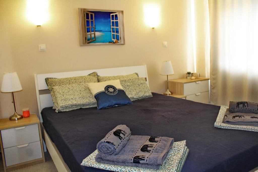ein Schlafzimmer mit einem großen Bett mit Handtüchern darauf in der Unterkunft Lovely 1-bedroom apartment with pool, 250 m to the beach in Pomorie