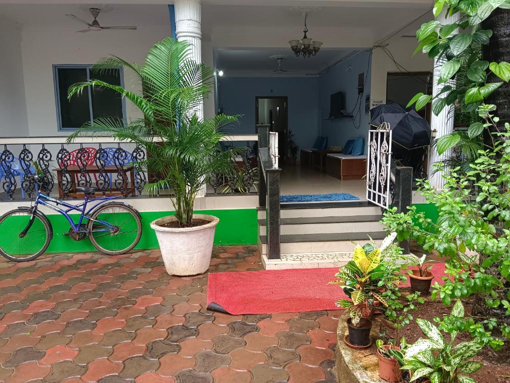 uma bicicleta estacionada ao lado de uma casa com uma planta em Palm Heaven em Canacona