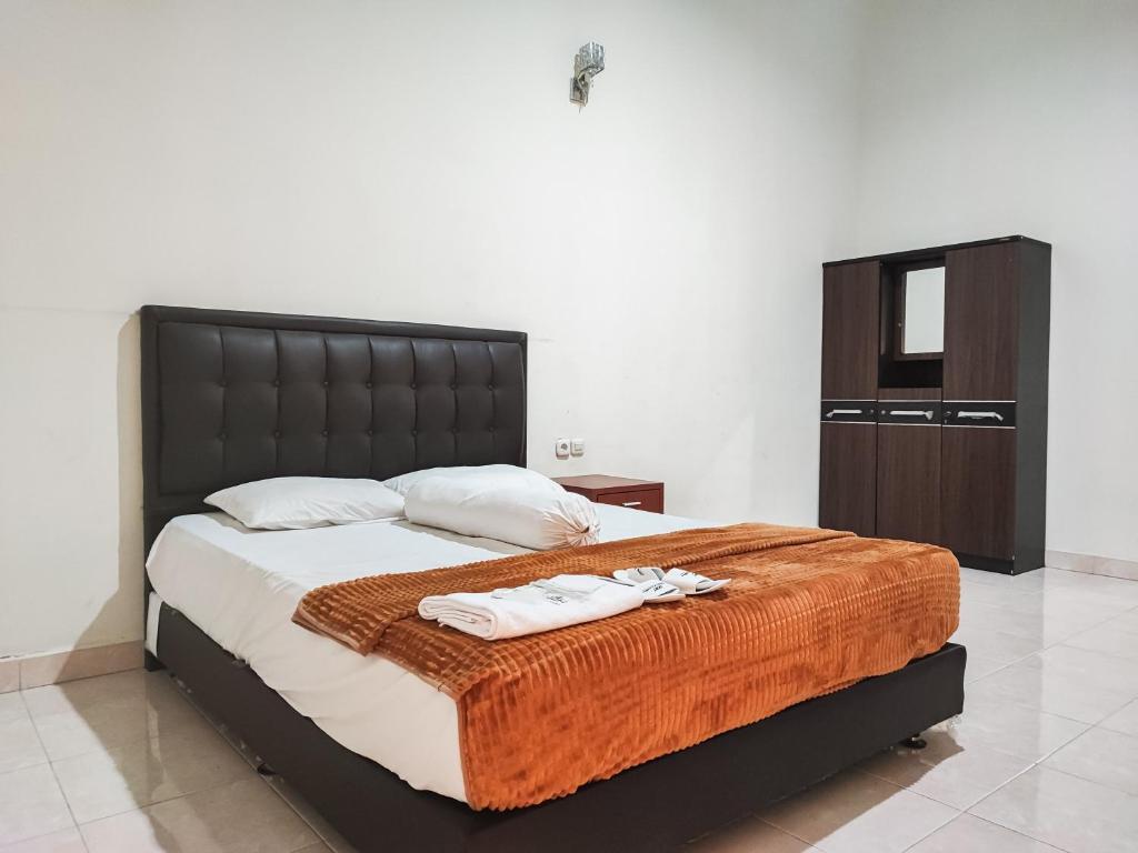 1 dormitorio con 1 cama grande y 2 toallas. en RedDoorz Plus Syariah near Simpang Rimbo Jambi en Kinati