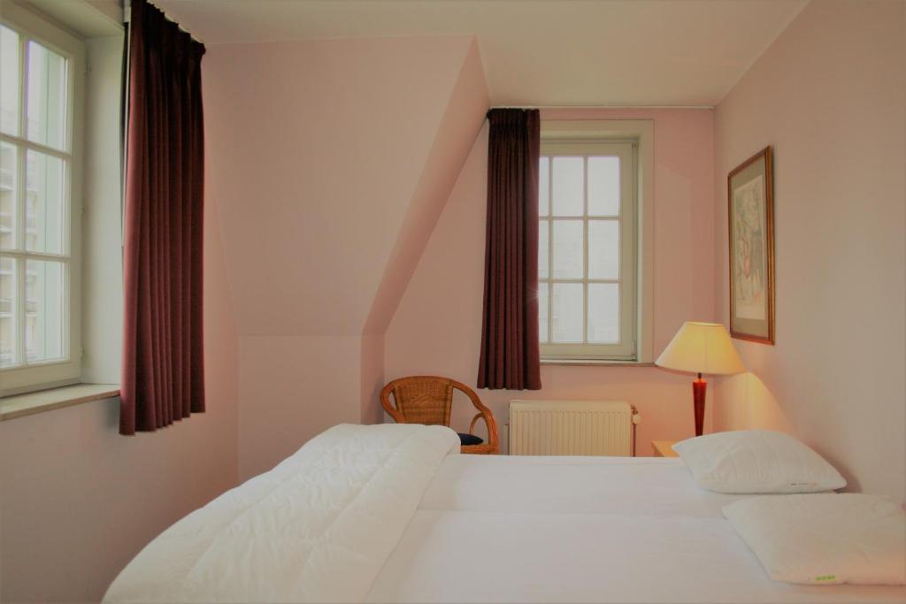 um quarto com 2 camas e 2 janelas em Tristan em De Haan