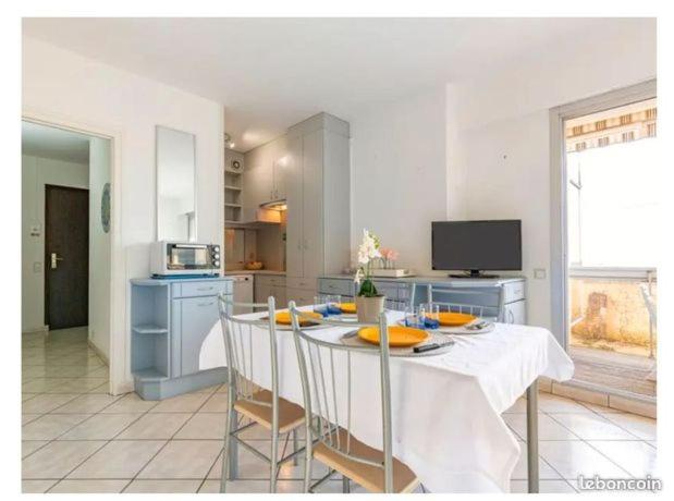 a kitchen with a table with chairs and a kitchen with a tableablish at Appartement la Galerne Royan-Pontaillac - plage casino in Vaux-sur-Mer