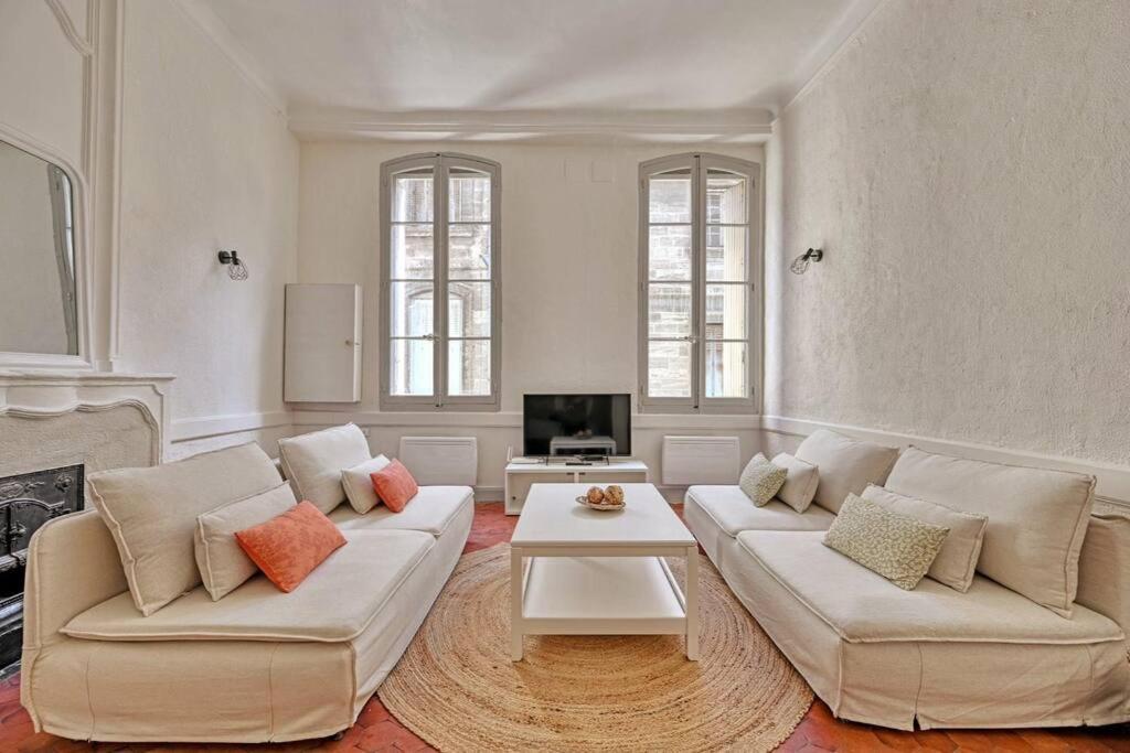 ein Wohnzimmer mit 2 weißen Sofas und einem Kamin in der Unterkunft Le Pi-gnotte - Wi-fi - CENTRE VILLE in Avignon