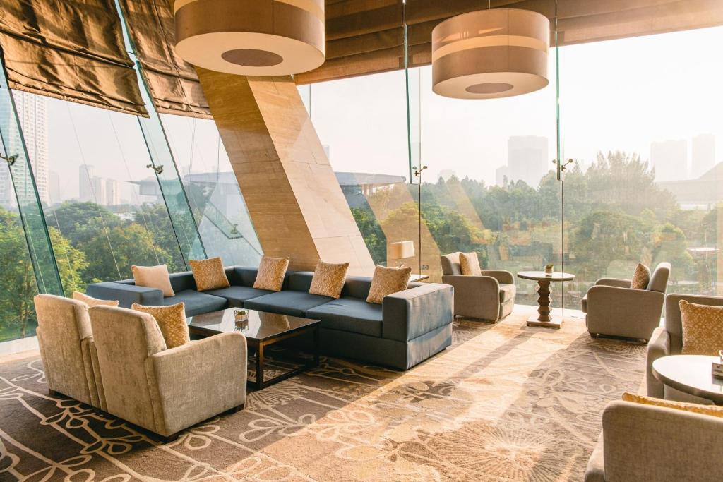 a lobby with a blue couch and chairs and windows at JW Marriott Hotel Hanoi in Hanoi