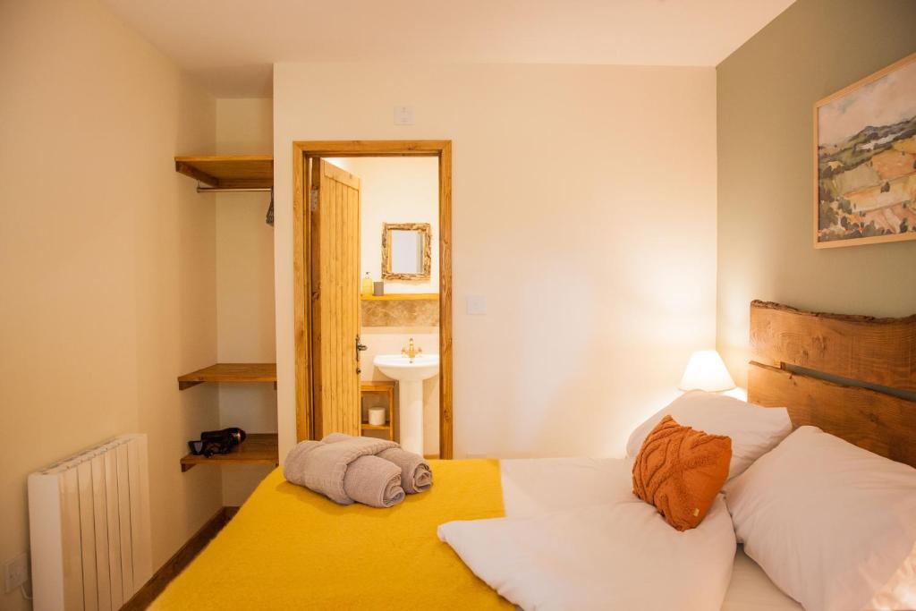 a bedroom with a bed and a mirror at HAYNE BARN ESTATE ECOLODGES in Hythe