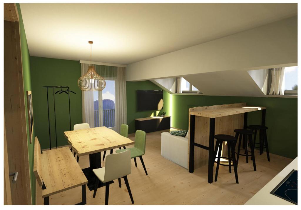 uma sala de estar com paredes verdes e mesas e cadeiras em Al Sole Mountain Chic em Folgaria