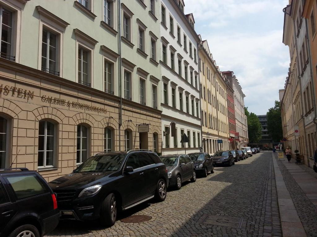 Ferienhaus im Barockviertel في درسدن: صف من السيارات تقف في شارع مجاور للمباني