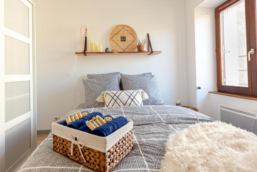 1 dormitorio con 1 cama y una cesta de toallas en Duplex lumineux 2 chambres centre zone piétonne, en Valence
