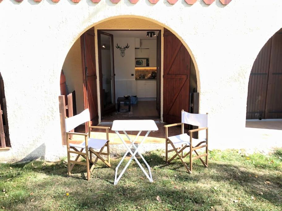 two chairs and a table in front of a building at Bleuets II in Sainte-Léocadie