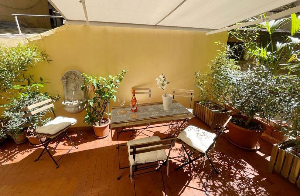 un patio con mesa, sillas y plantas en CASA ANTICA - antique apartment with private terrace, en Roma