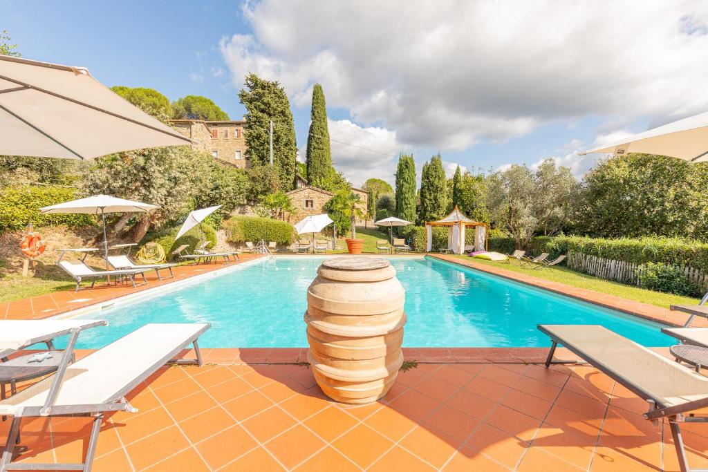 a swimming pool with a villa and a swimming pool at Borgo Dolci Colline Resort Limonaia in Castiglion Fiorentino