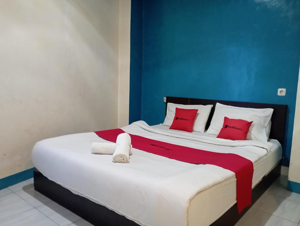 a bedroom with a large bed with red pillows at RedDoorz at Jalan Sudirman Purwokerto in Purwokerto