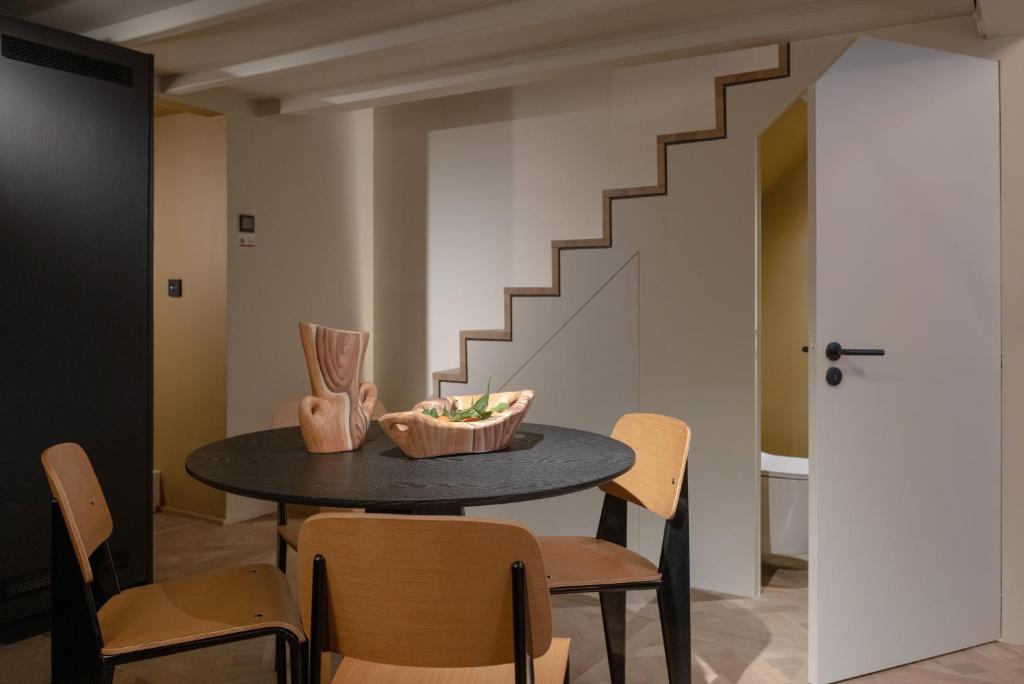 uma sala de jantar com uma mesa e cadeiras e uma escadaria em MiHotel Serlin em Lyon