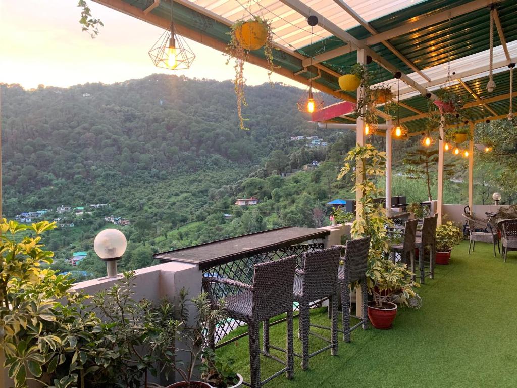 einen Balkon mit Stühlen und Bergblick in der Unterkunft The Panda in Dharamshala