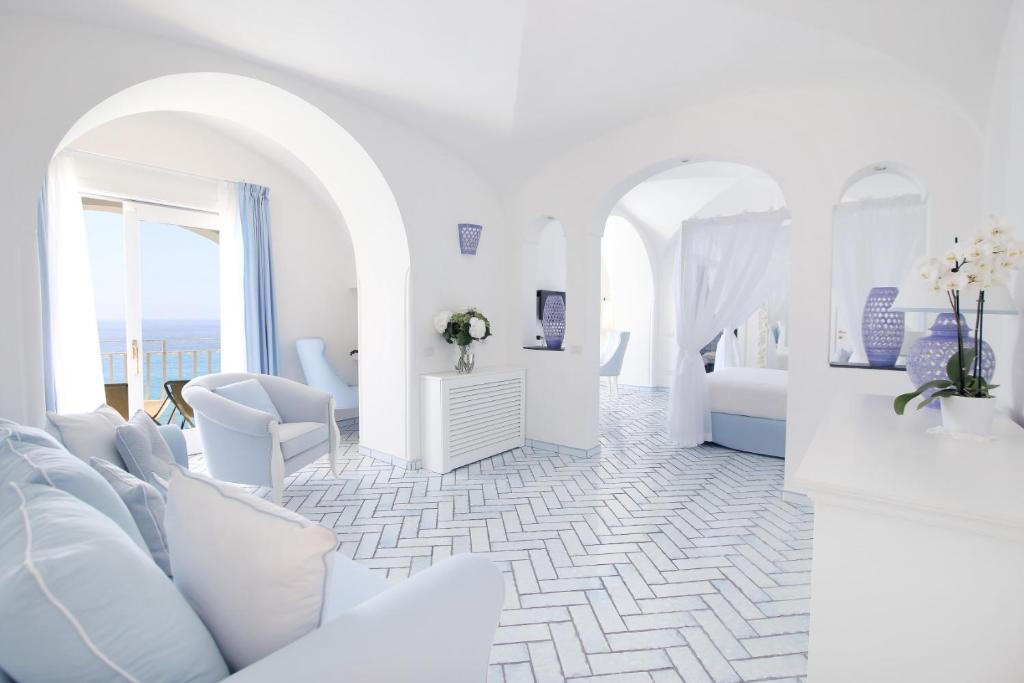 a white room with white furniture and a room with a bed at Hotel Marincanto in Positano