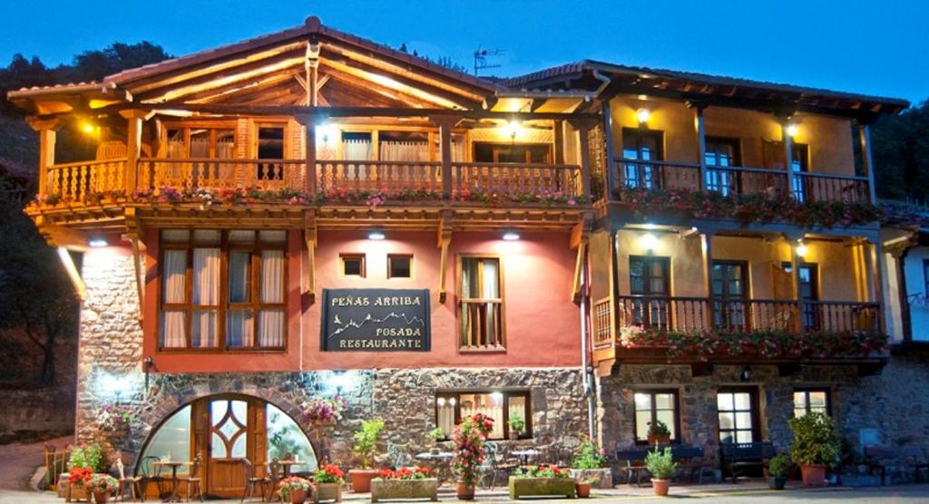 a large building with a balcony on top of it at Posada Peñas Arriba in Lon