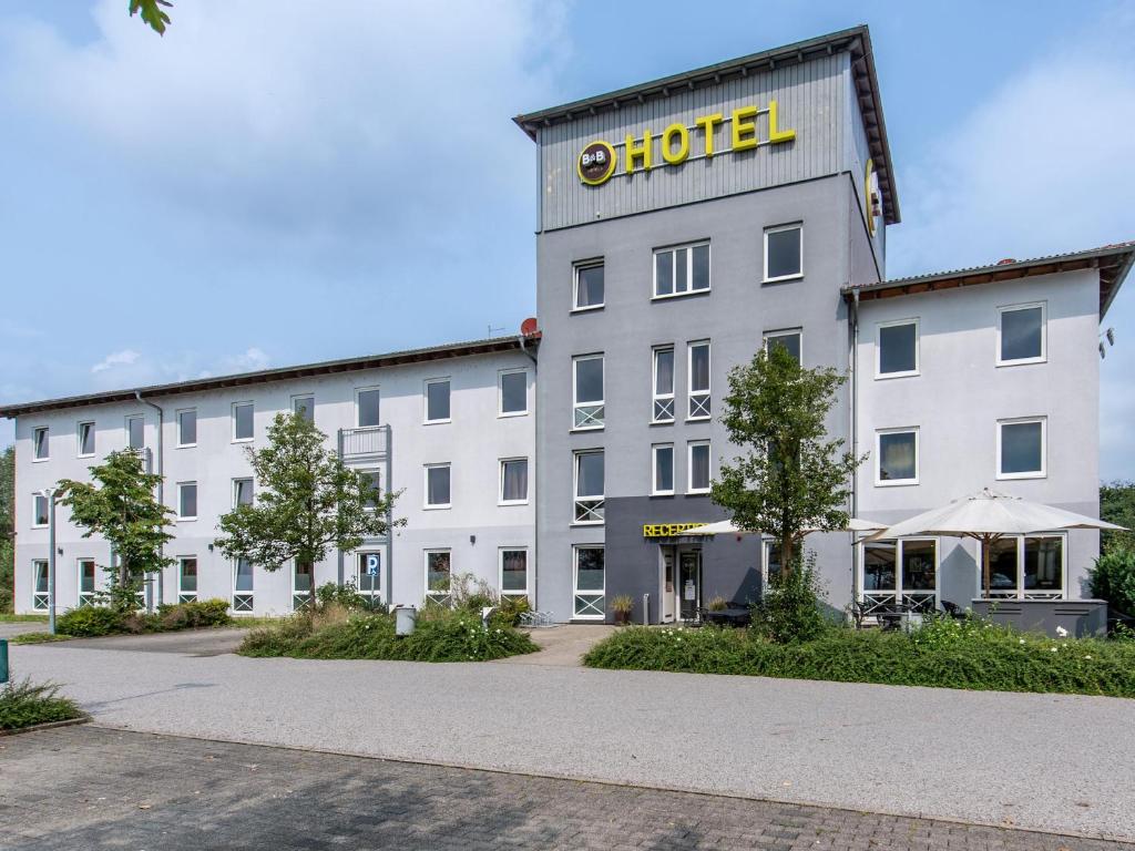 un gran edificio blanco con un cartel. en B&B Hotel Schweinfurt-Süd, en Schweinfurt