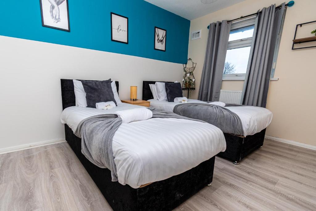 - 3 lits dans une chambre aux murs bleus dans l'établissement Fife - Driveway Parking Spacious 4 bed house Sleeps 6 Ideal Contractor Accommodation, à Gateshead