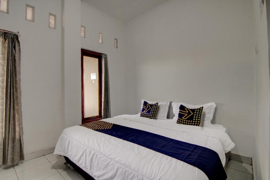 een slaapkamer met een groot bed met blauwe en witte lakens bij SPOT ON 92635 Homestay Baiturrahmah Syariah in Pekanbaru