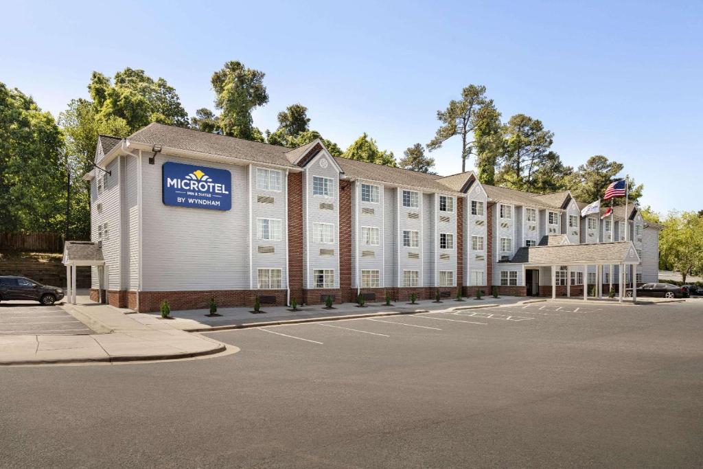 un grande edificio con un cartello sulla parte anteriore di Microtel Inn & Suites by Wyndham Raleigh a Raleigh