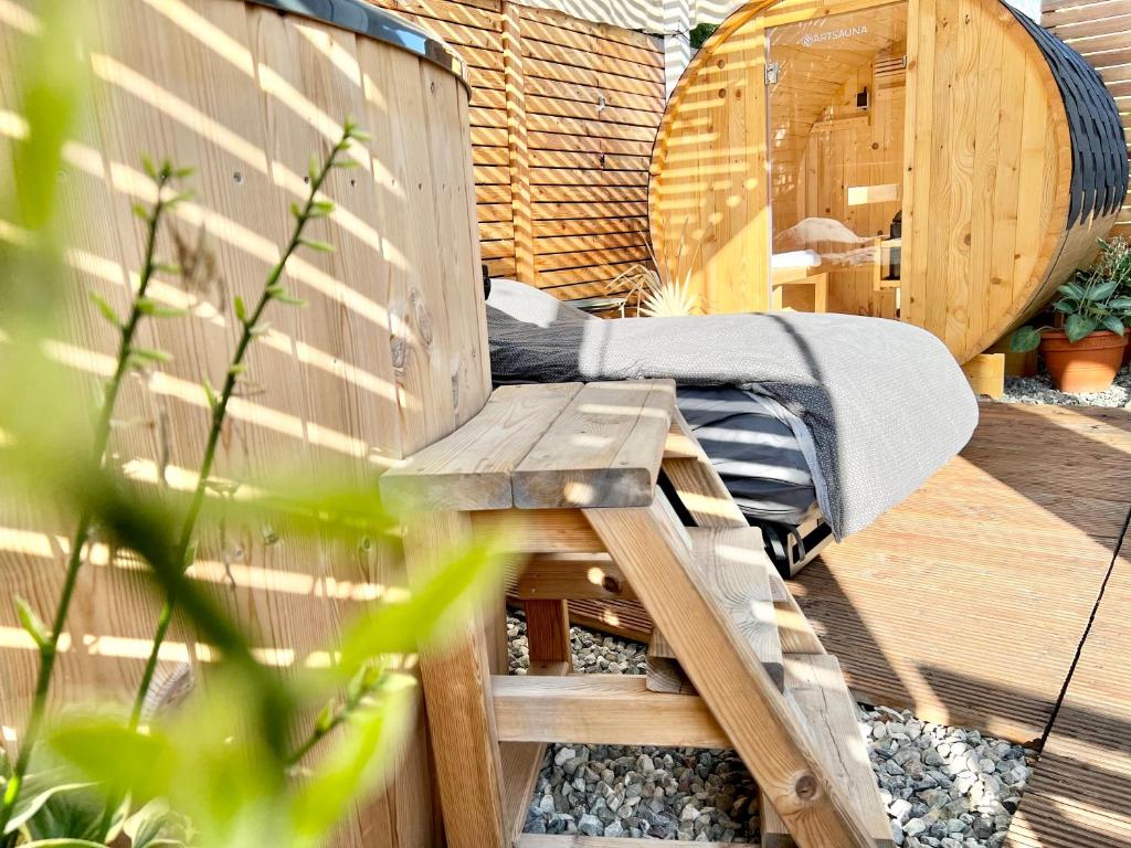 a wooden bench sitting on a deck next to a hot tub at Tiny House Gänseblümchen in Kirchanschöring