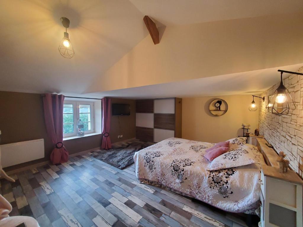 um quarto com uma cama e uma parede de tijolos em Chambre 25m2 avec salle de douche em Saint-André-de-la-Marche