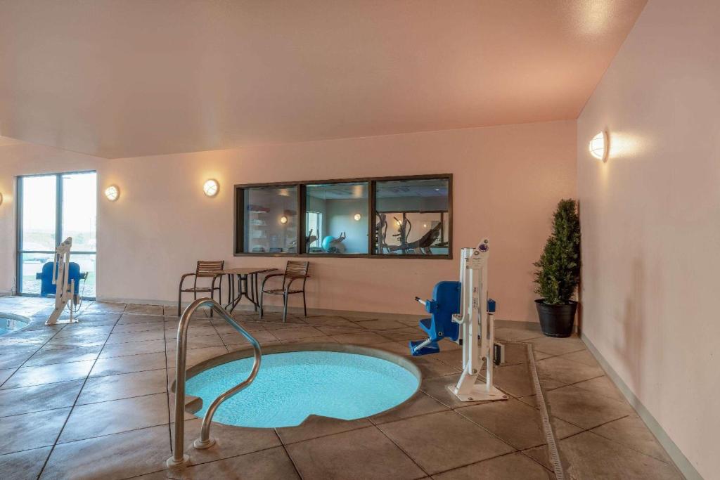 a room with a swimming pool with a water slide at Baymont by Wyndham Rapid City in Rapid City