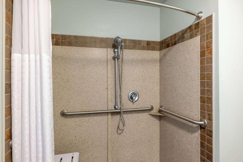 a shower in a bathroom with a shower curtain at Baymont by Wyndham Rapid City in Rapid City