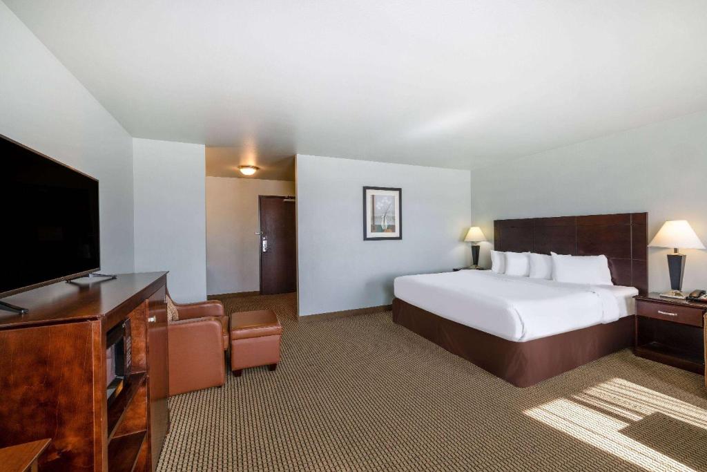 a hotel room with a bed and a flat screen tv at Baymont by Wyndham Rapid City in Rapid City