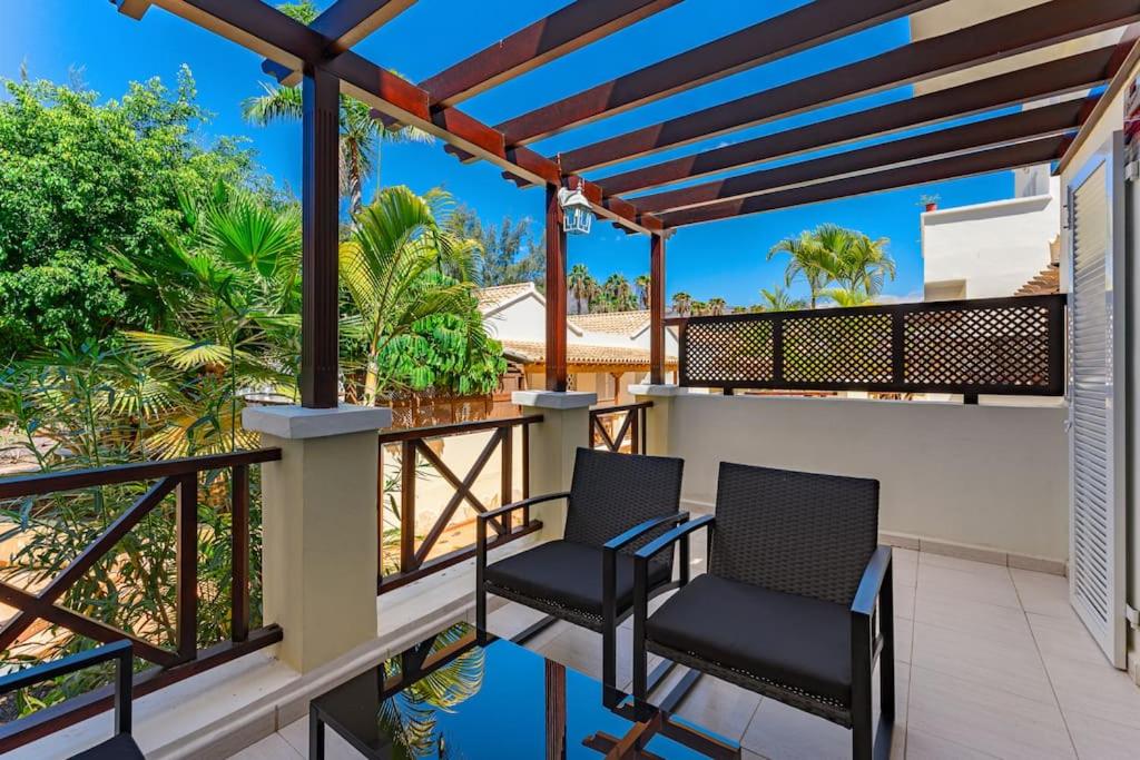 two chairs on a balcony with a view of the ocean at Oasis Golf house in Las Americas in Arona