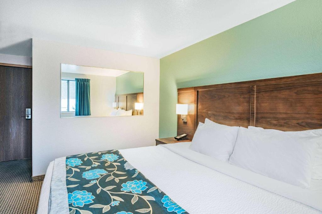 a large bed in a hotel room with a bed sidx sidx sidx at Baymont by Wyndham Keystone Near Mt. Rushmore in Keystone