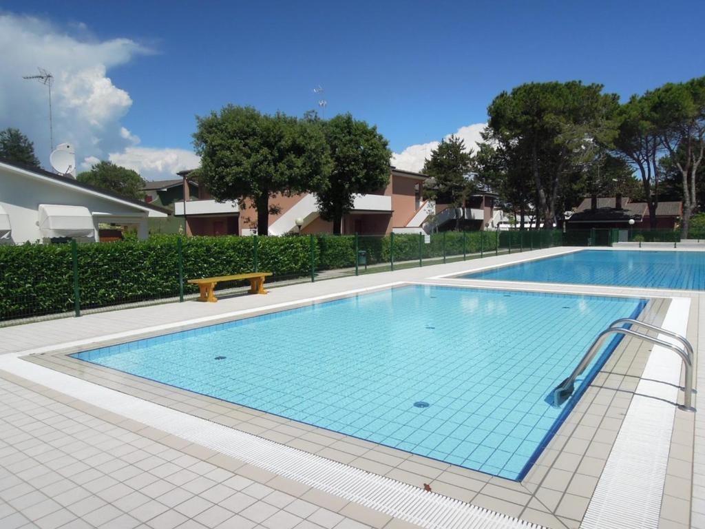 una gran piscina con un banco al lado en Modern flat in a fantastic residence with pool, en Bibione