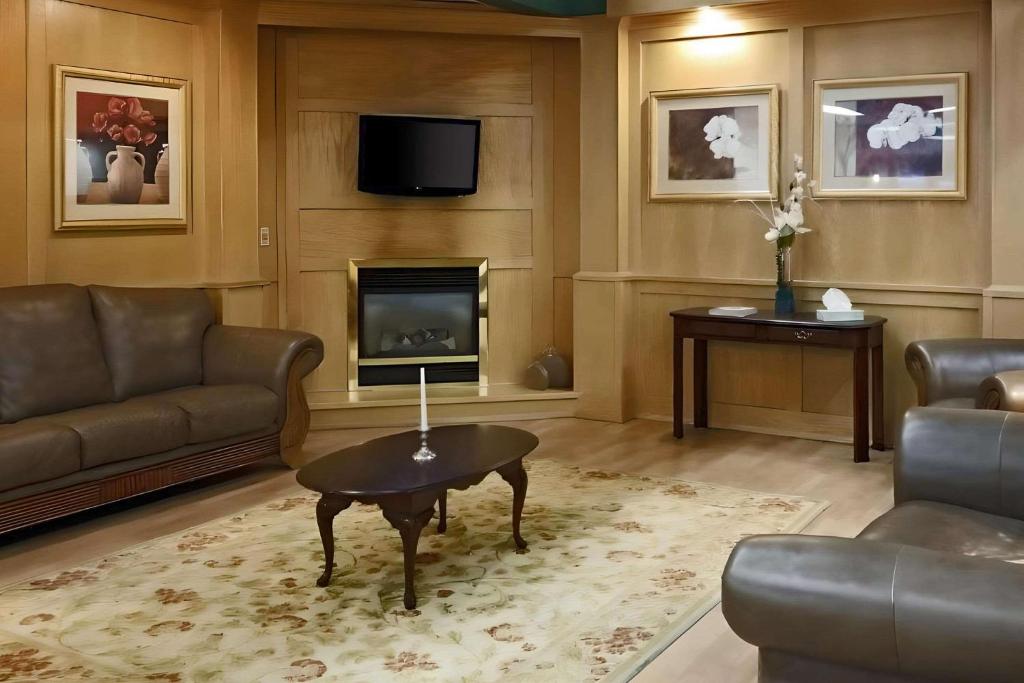 a living room with a couch and a table and a fireplace at Pottsville Inn in Pottsville