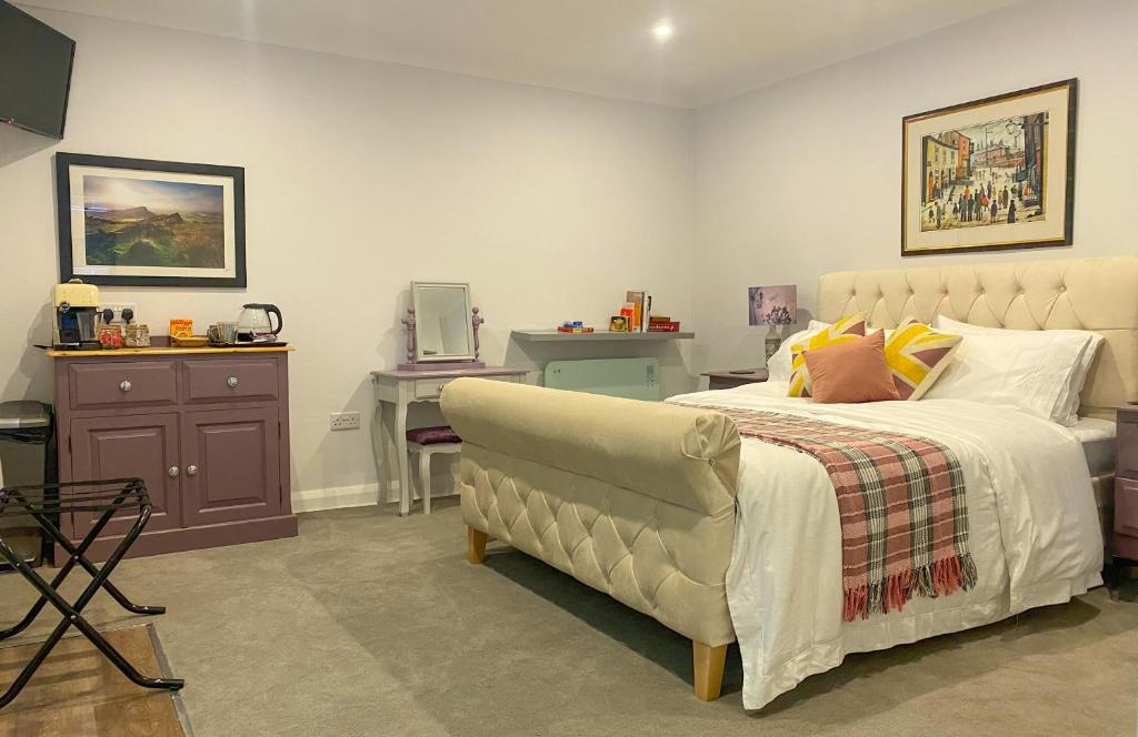 a bedroom with a bed with a chair and a desk at The Midway in Adlington