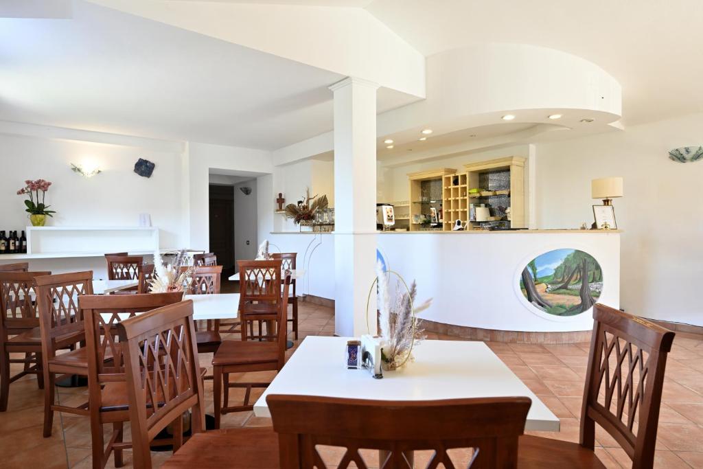 a restaurant with wooden tables and chairs and a counter at Hotel Marie Claire in Lanusei