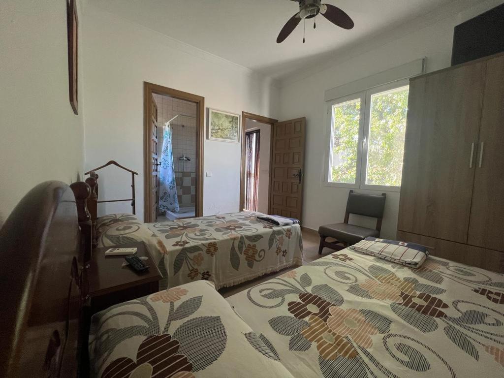 a bedroom with two beds and a fan at Alojamiento rural Huerta Mandre in Cuevas del Becerro