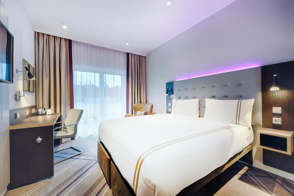 a hotel room with a large bed and a desk at Premier Inn Frankfurt City Europaviertel in Frankfurt/Main