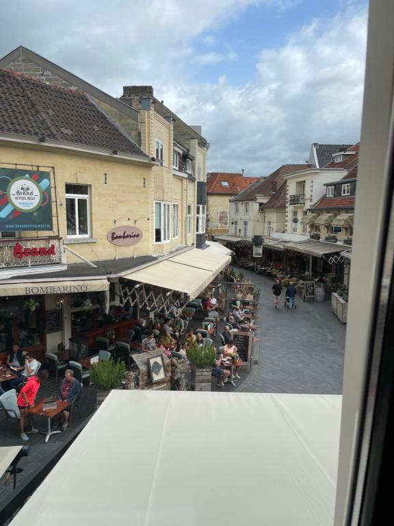 a group of people sitting at tables in a street at Castle View 2 in Valkenburg