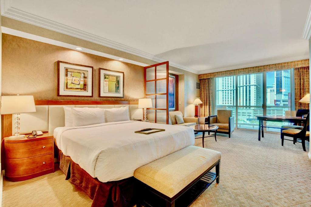 Habitación de hotel con cama grande y escritorio. en Strip View Balcony Suites - No Resort Fee ! en Las Vegas