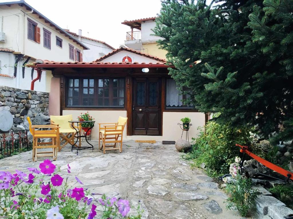 a house with a patio and a table and chairs at Panthea Cottage in Stavroupoli