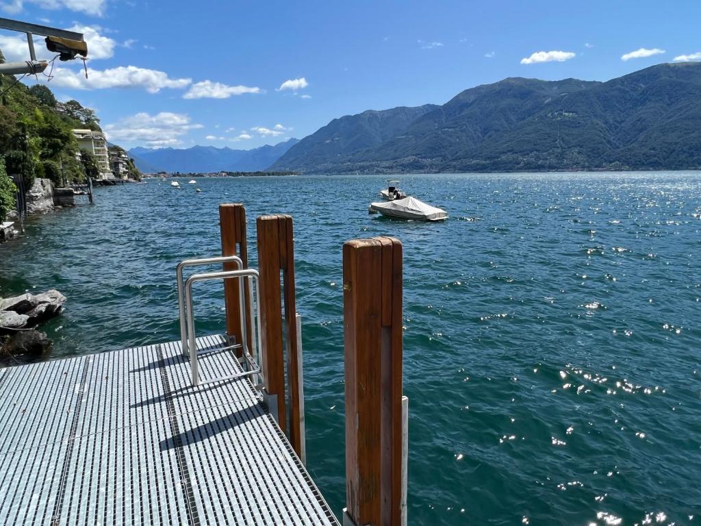ein Boot auf einem Wasserkörper mit einem Boot in der Unterkunft Villa Aurora: Porto Ronco in Ronco sopra Ascona