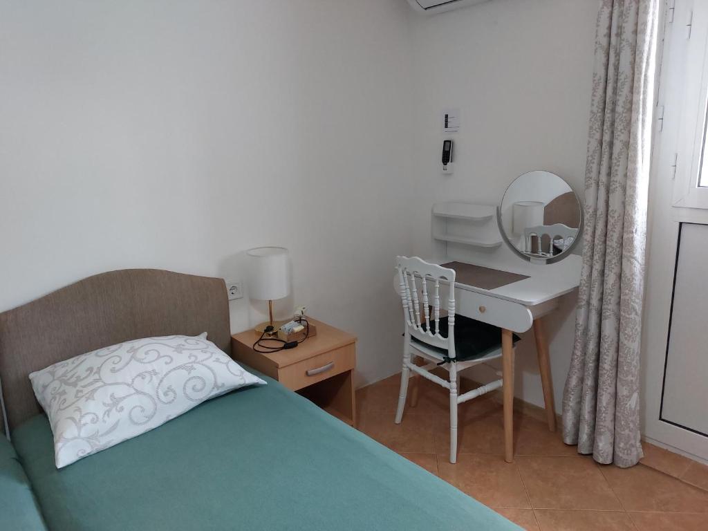 a bedroom with a bed and a desk with a mirror at Vicky Apartments in Kotor