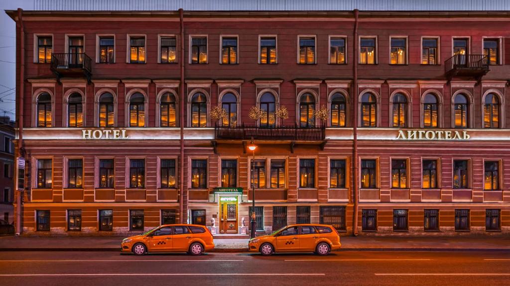 dos coches estacionados frente a un edificio en Ligotel, en San Petersburgo