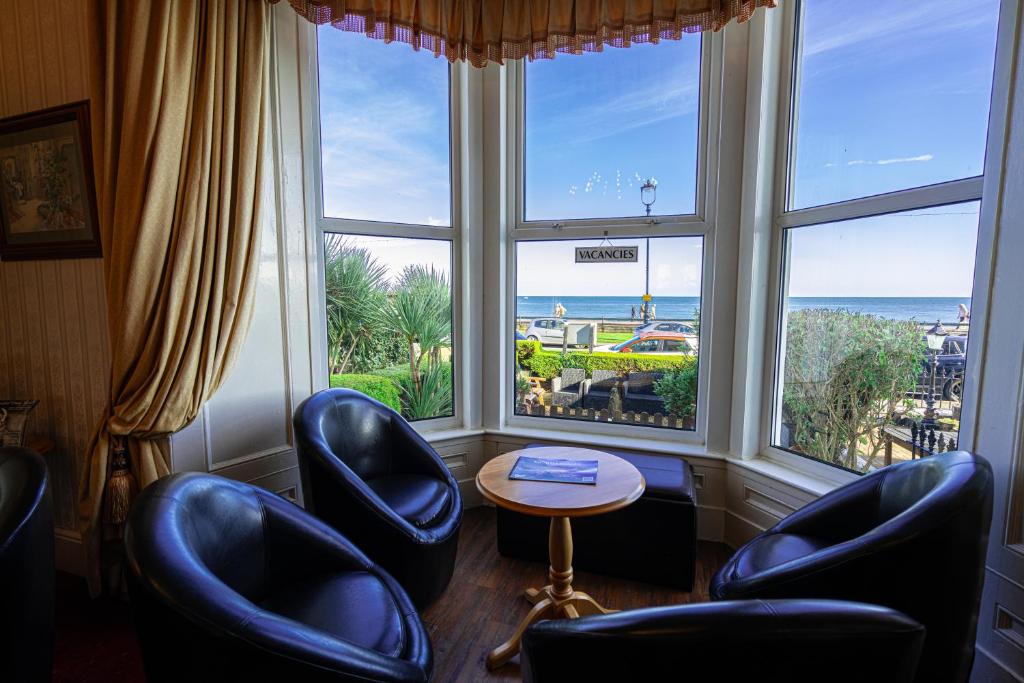 Can-Y-Bae Hotel في خلنددنو: غرفة بها كراسي ونافذة مطلة على المحيط