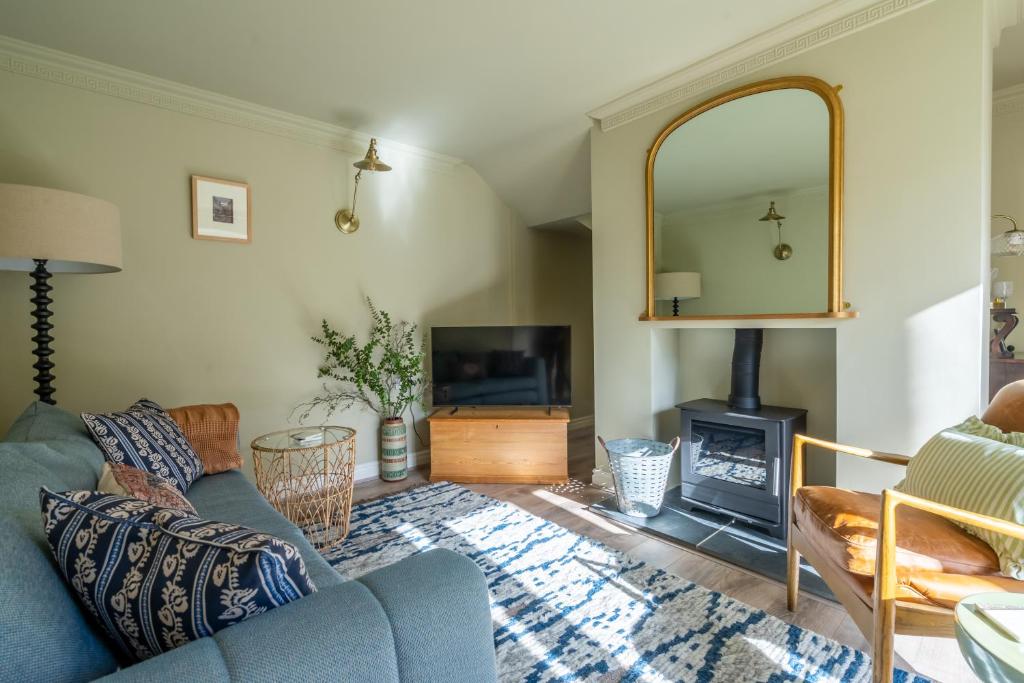 a living room with a blue couch and a fireplace at 3 The Mews in York