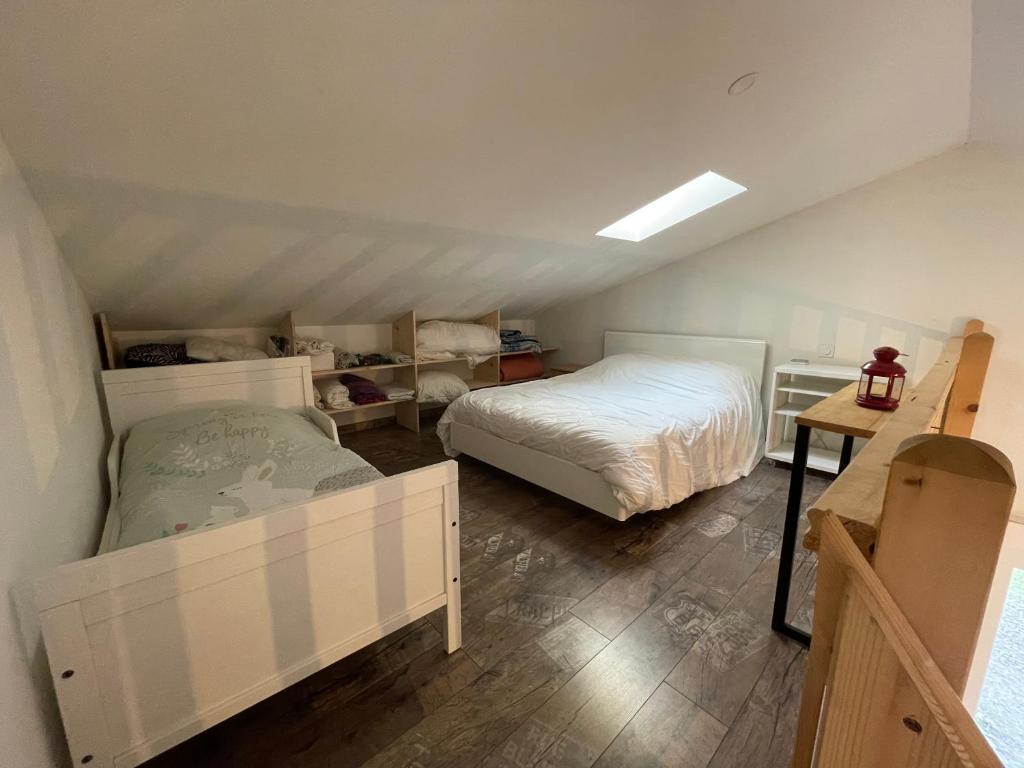 Schlafzimmer im Dachgeschoss mit 2 Betten und einem Tisch in der Unterkunft Eco-gîte en pleine nature in Lisle-sur-Tarn