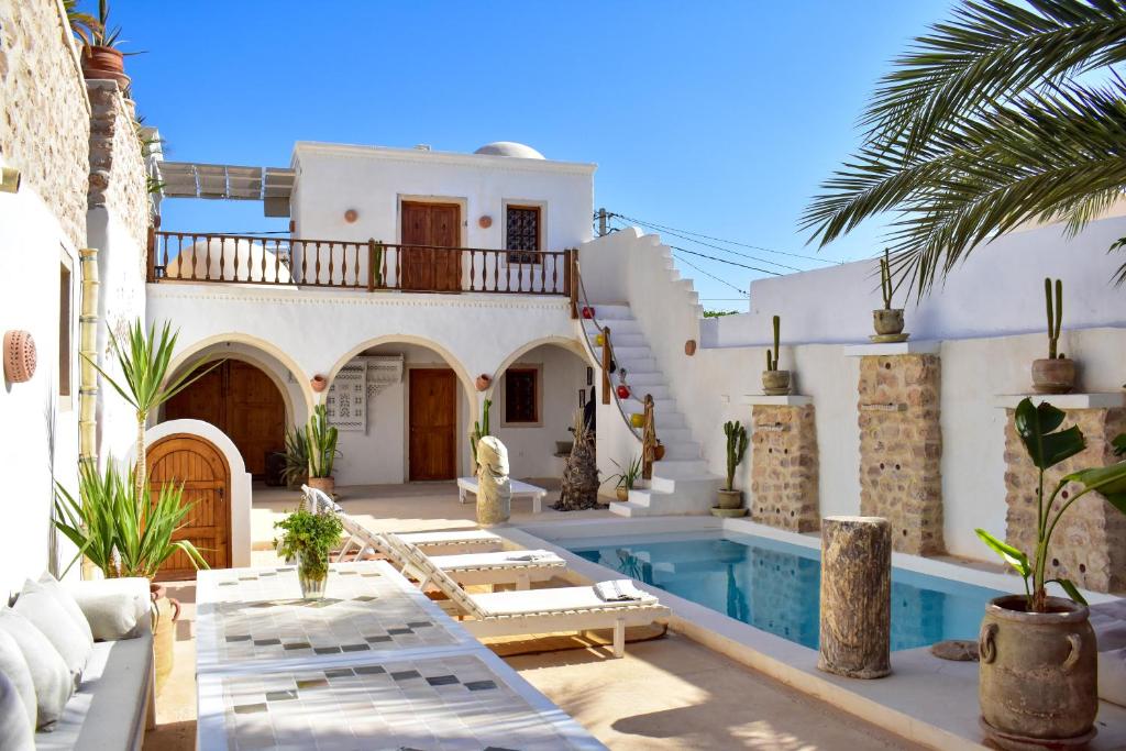 a villa with a swimming pool and a house at Dar Shams in Erriadh