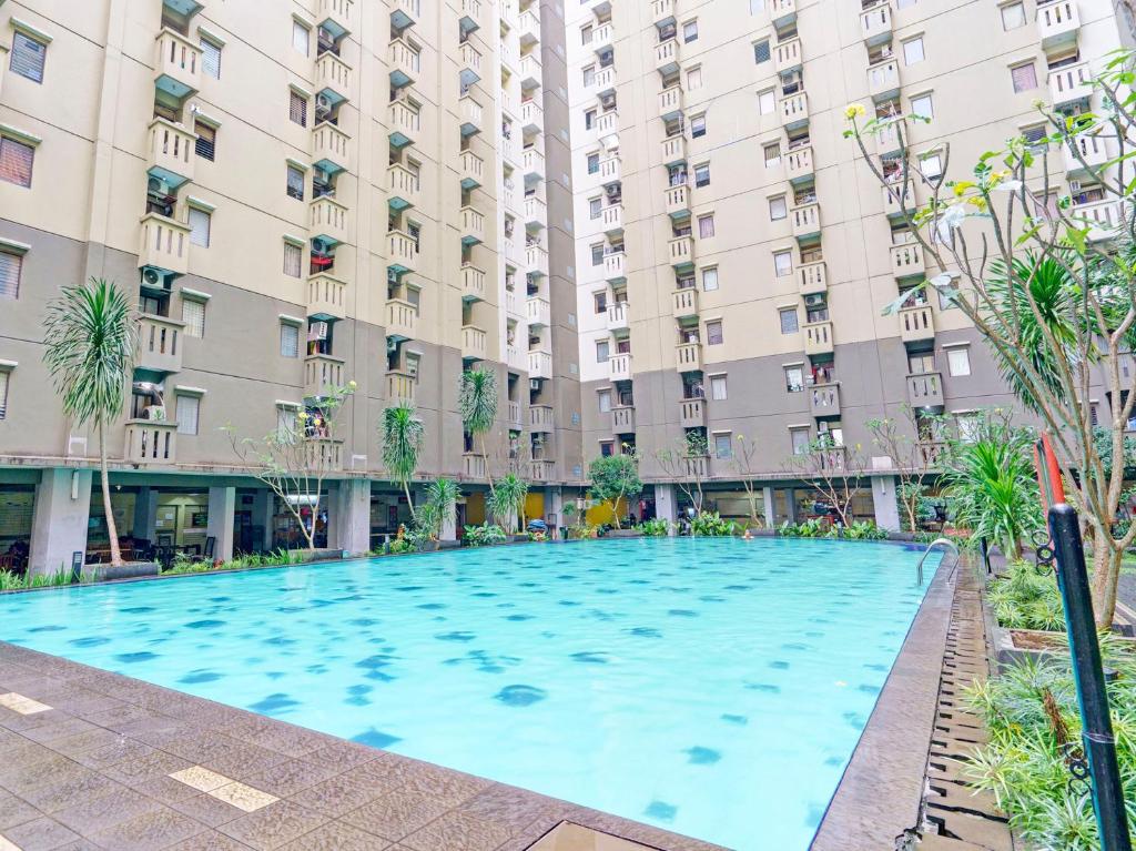 a large swimming pool in front of a large building at OYO Life 92976 Apartement Jarrdin By Apato in Bandung