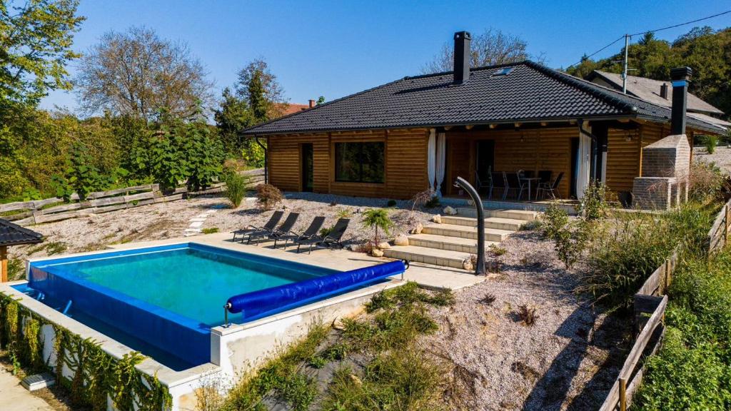 uma casa com piscina em frente a uma casa em Laganini Country em Samobor