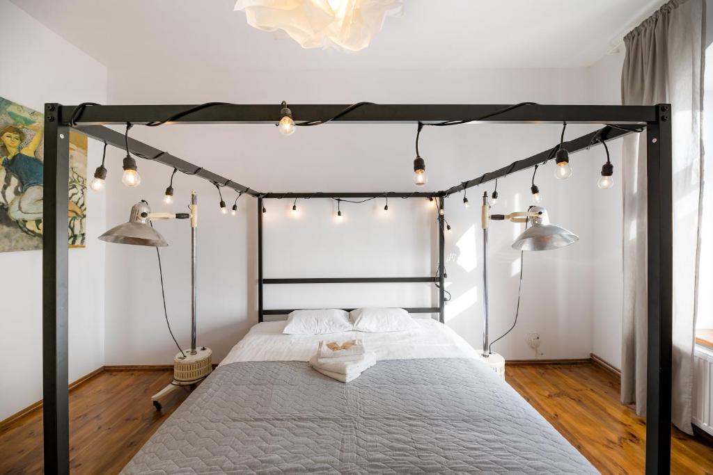 a bedroom with a black canopy bed with lights at Malarskie Atelier in Toruń