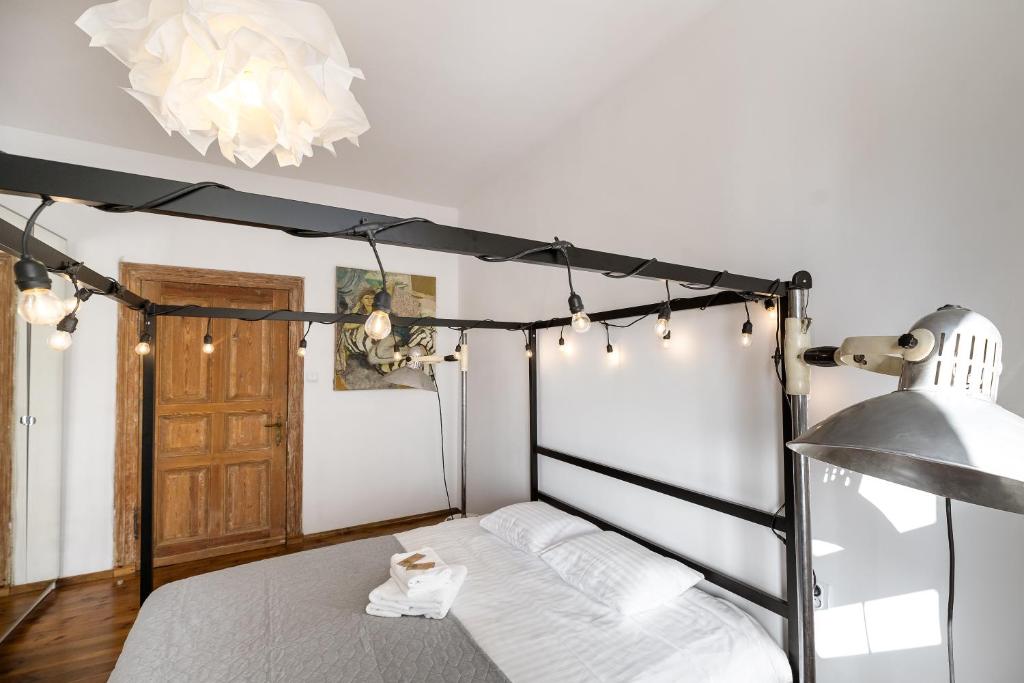 sypialnia z czarno-białym łóżkiem z baldachimem i oświetleniem w obiekcie Malarskie Atelier w Toruniu